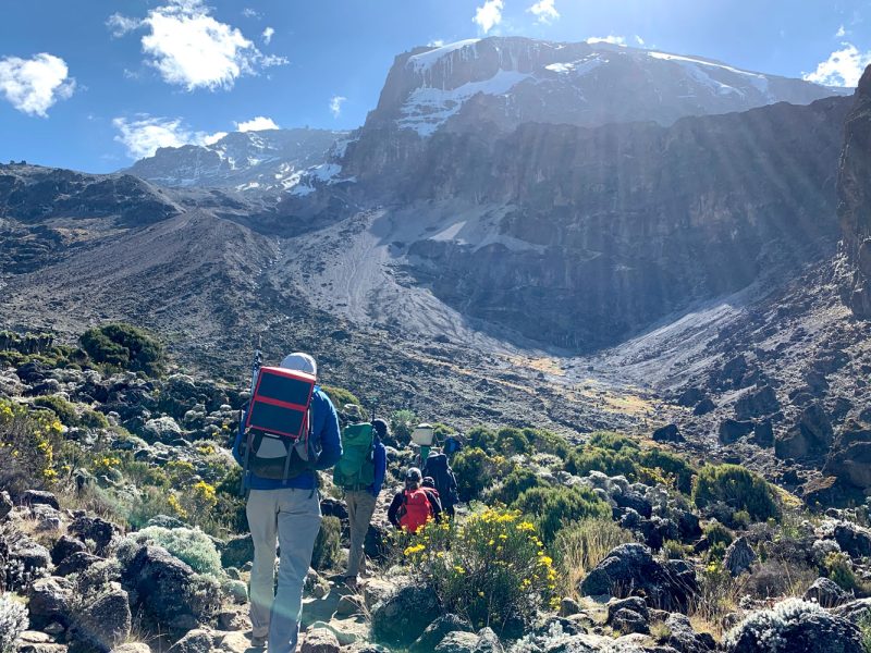 Hikers on the 8 Day Mount Kilimanjaro Lemosho Route with a majestoc view of mount kilimanjaro in view.